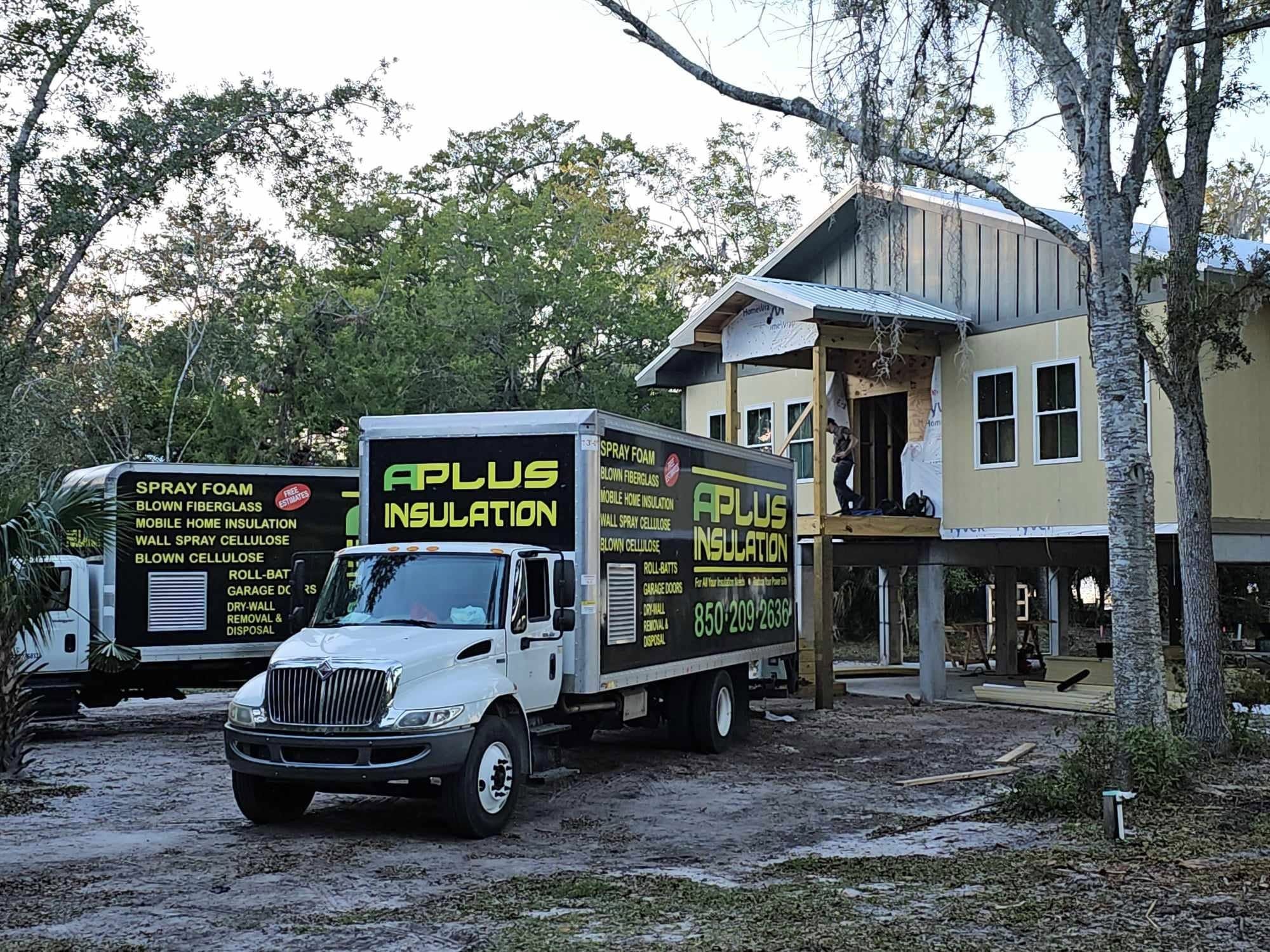 A Plus Insulation trucks on site at a new coastal home under construction